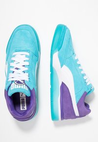 Light blue suede sneakers with white accents, purple detailing, and a translucent teal sole. Features white laces and a logo on the tongue.