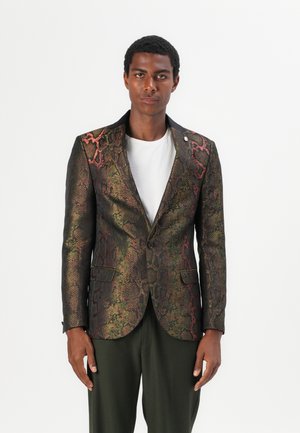 Blazer estructurado en tejido con patrón de serpiente, con una base oscura y acentos en dorado y rojo. Corte ajustado, cierre de un botón y cuello de solapa.