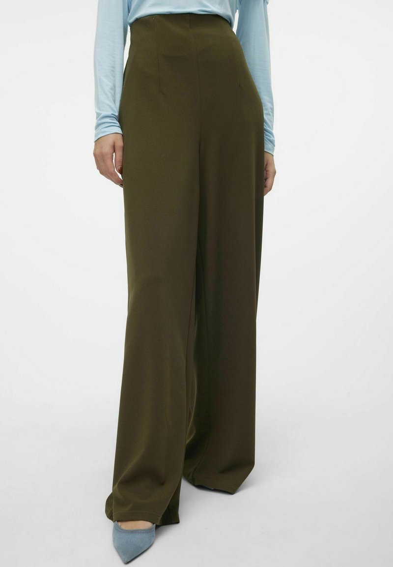 Olivgrön, högmidjade byxor med vida ben. Tillverkade av ett smidigt material, med framveck och subtila sömdetaljer.