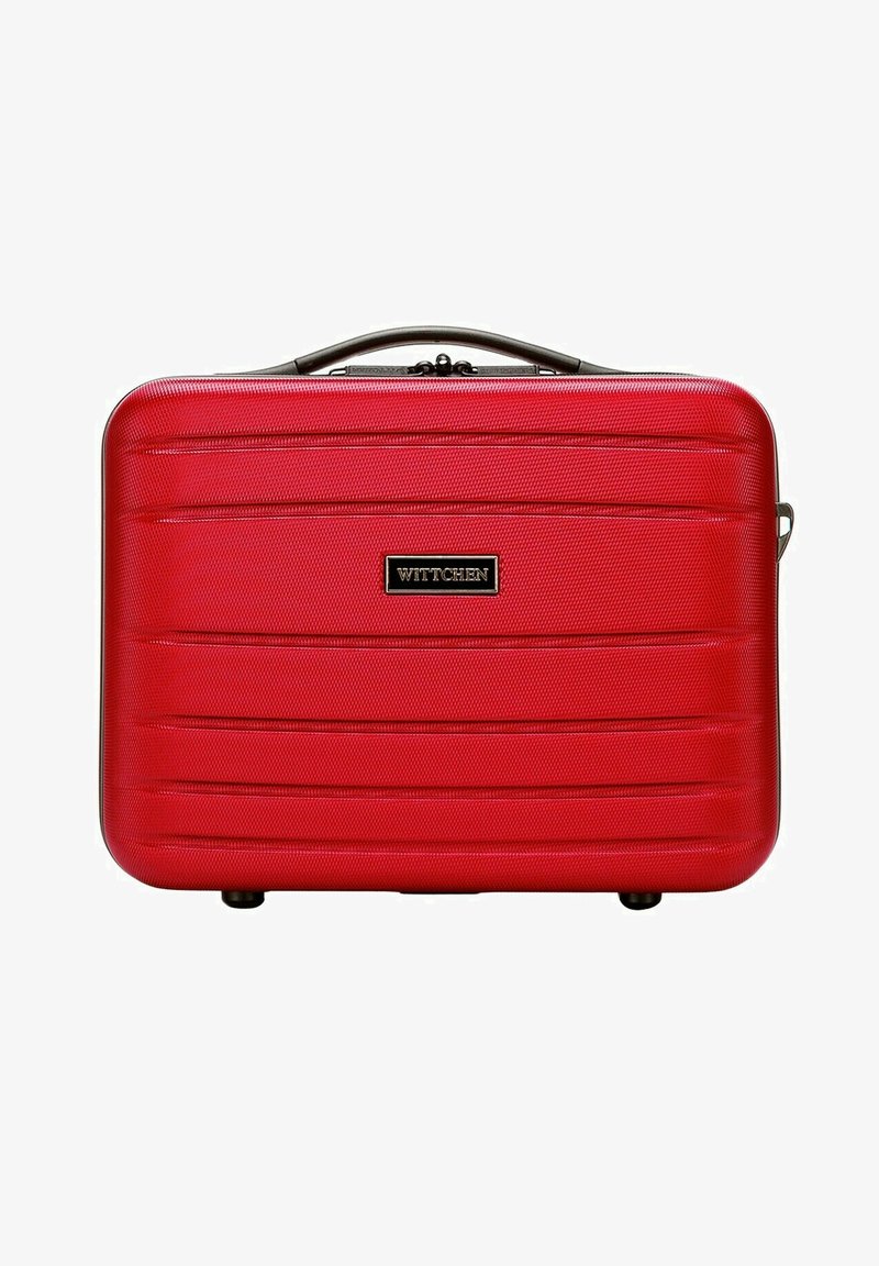 Valigia rigida rossa con superficie texturizzata, dotata di scanalature orizzontali, un manico nero e una placca del logo ben visibile sulla parte frontale.