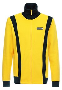 Gul zip-up jacka med hög krage, med svarta sidopaneler och en liten logotyp på bröstet. Mjuk tyg och ribbade ärmmuddar.