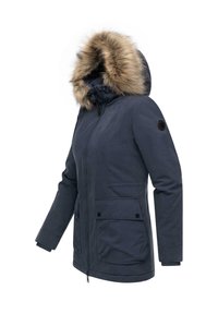 Tumesinine parka jakk, millel on karvane kapuuts, ees zip-sulgur, kaks suurt taskut ja ribikätised. Materjal näib olevat veekindel ja sile tekstuuriga.