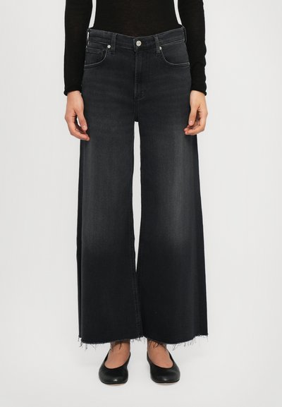 Jeans in denim nero a gamba larga con orlo sfilacciato, caratterizzati da un classico design a cinque tasche e accessori in metallo argentato alla vita.