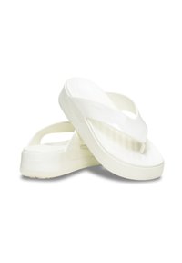 Białe klapki z gładkim, błyszczącym wykończeniem. Posiadają pasek między palcami i teksturowaną wkładkę. Podeszwa jest lekko podwyższona.