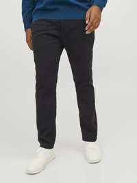 Marinblå bomullschinos med slim fit, med en slät yta och framfickor, tillsammans med vita sneakers.