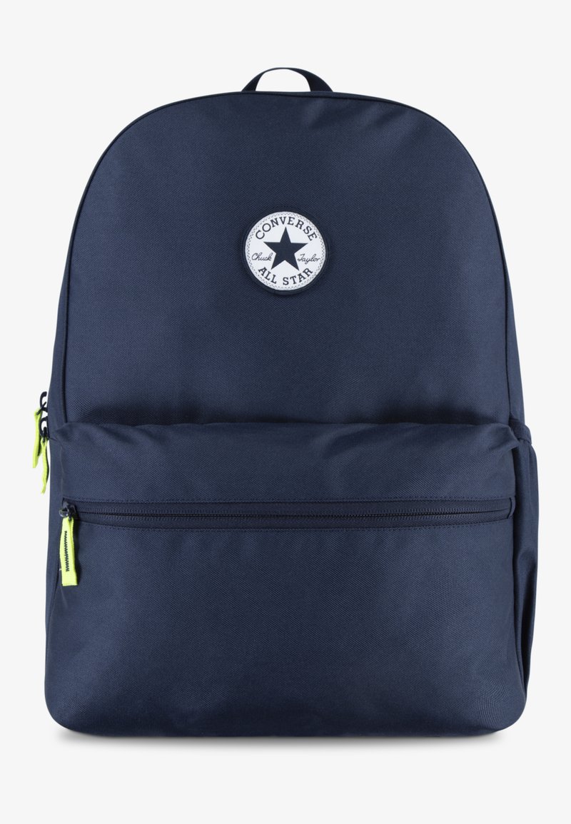 Sac à dos en tissu bleu marine avec un logo rond blanc, une poignée supérieure et deux compartiments zippés avec des tirettes vert fluo.