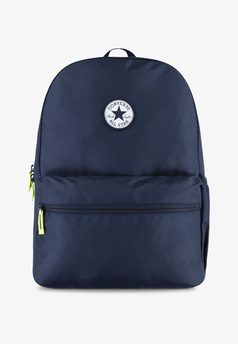 Mochila de tela azul marino con un logotipo blanco redondo, asa superior de transporte y dos compartimentos con cremallera que cuentan con tiradores en verde neón.