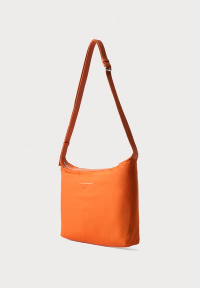 Φωτεινή πορτοκαλί ορθογώνια τσάντα crossbody με ρυθμιζόμενο λουρί ώμου και κορυφαίο φερμουάρ σε απλό φωτεινό φόντο.