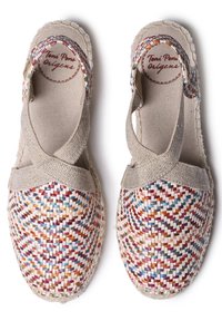 Kudottu espadrille, jossa on monivärinen punottu kuvio. Vaaleanbeige kangas ristiin menevillä nahkahihnoilla. Pyöreä kärki ja teksturoitu pohja.
