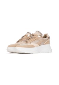 Baskets de sport beiges avec tige en mesh et en daim, dotées d'une semelle épaisse blanche, de lacets et d'accents métalliques pour plus de détails.