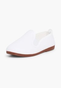Witte canvas instapshoe met een ronde teen, dunne rubberen zool en geen zichtbare hardware of patronen. Glad oppervlak overal.