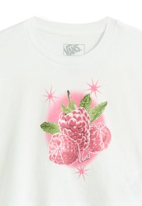 Camiseta blanca con un gráfico de frambuesa, hojas verdes y acentos en rosa, incluyendo formas parecidas a estrellas alrededor de la ilustración.