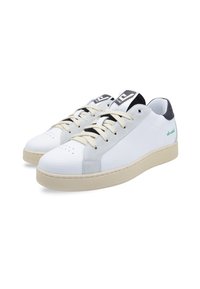 White leather sneakers with gray suede accents, beige rubber sole, round toe, and beige laces. Black and white branding on tongue.