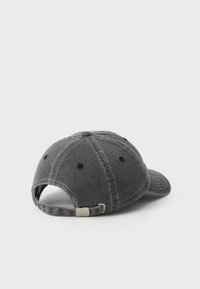 Căciulă de baseball gri, cu o vizieră curbată, confecționată din material denim. Prezintă cusături albe contrastante și un sistem de închidere din metal, reglabil, în partea din spate.