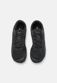Black athletic shoes with a textured mesh upper, reinforced toe, and rugged rubber sole. Features black laces and branding on the tongue.