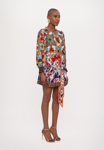 Colorful patterned dress with a round neckline, long sleeves, and a tie waist. Features vibrant floral and paisley designs in various hues.