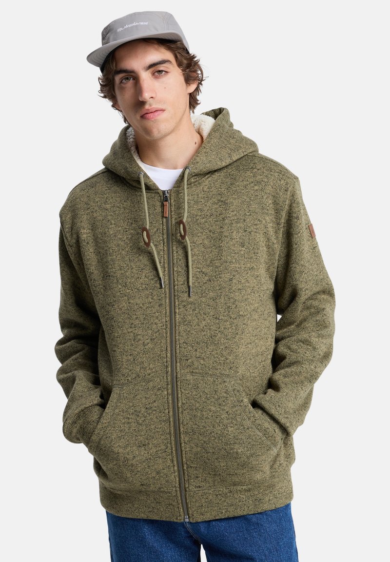 Groene rits-hoodie met een gestructureerde afwerking, voorzien van trekkoorden, voorzakken en een zachte binnenvoering.