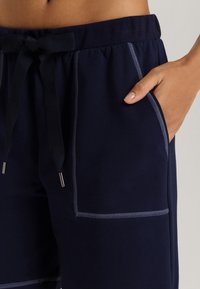 Pantaloni corti navy con vestibilità rilassata, dotati di cuciture a contrasto di colore azzurro chiaro, vita con cordoncino e tasche laterali.