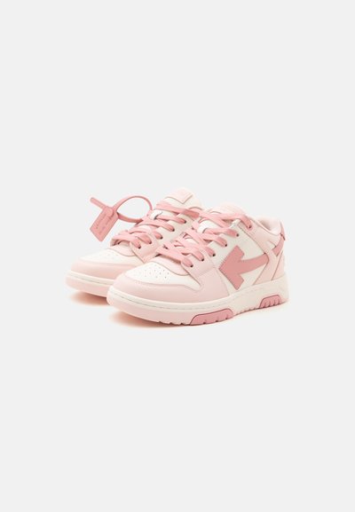 Ζευγάρι παπούτσια τύπου sneakers με χαμηλή σόλα σε ανοιχτό ροζ και λευκό χρώμα, με ροζ κορδόνια και διακοσμητικό βέλος στα πλάγια, σε λευκό φόντο.