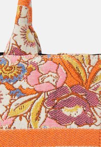 Torebka typu tote z tkanym wzorem kwiatowym, z intensywnymi różowymi, pomarańczowymi i niebieskimi wzorami na teksturowanej tkaninie, z kontrastującą pomarańczową podstawą i podwójnymi uchwytami.