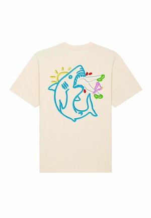 T-shirt couleur crème présentant un design de requin brodé en bleu avec des accents colorés, incluant un soleil et des plantes, au dos.