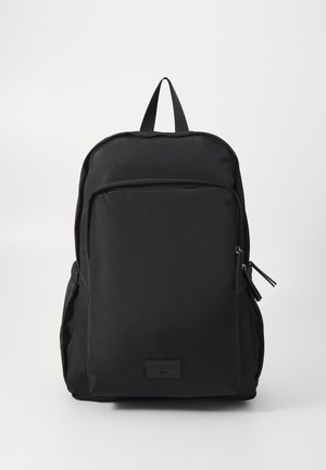 Schwarzer Rucksack mit einer vorderen Reißverschlusstasche, gepolsterten Schulterriemen und einem oberen Griff vor weißem Hintergrund.