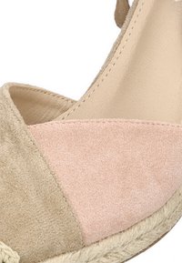 Sandalia de cuña de ante beige y rosa con suela de yute trenzado. Presenta un diseño de bloques de color triangular y un acabado texturizado.