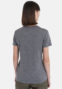 Szary, krótki t-shirt z teksturowanej tkaniny, z okrągłym dekoltem i lekko zaokrąglonym dołem, widok z tyłu.