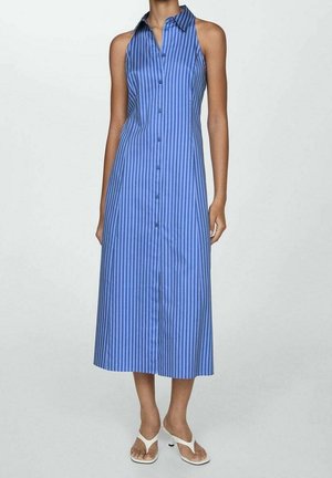Niebieska sukienka na guziki bez rękawów z pionowymi paskami i kołnierzykiem, noszona z białymi sandałami na obcasie z odkrytymi palcami, prezentowana na stojącej modelce.