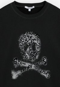 Felpa nera con una grafica di teschio e tibie in stile usurato. Il design include testo ripetuto in nero su uno sfondo grigio maculato.