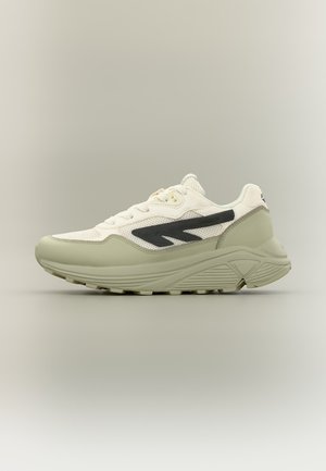 Zapatilla tipo sneaker baja con parte superior de malla blanca, suela beige clara y diseño negro en forma de onda en el lateral.