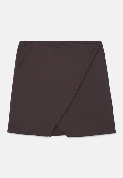 Jupe mini noire en tissu lisse, présentant un design enroulé diagonal et un ourlet droit. Pas de fermetures visibles ni de motifs.