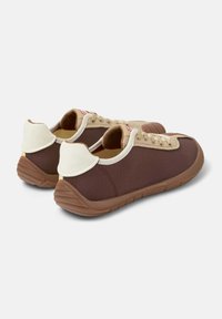 Sneaker in tessuto marrone con dettagli in beige, punta rotonda, suola piatta in gomma marrone e linguette sul tallone di colore chiaro a contrasto.