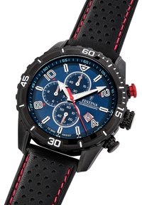 Melnā hronogrāfa pulksteņa ar zilu ciparnīcu, baltām un sarkaniem akcentiem, marķieriem, subciparnīcām un faktūru melnu ādas siksniņu ar sarkaniem dūrieniem.