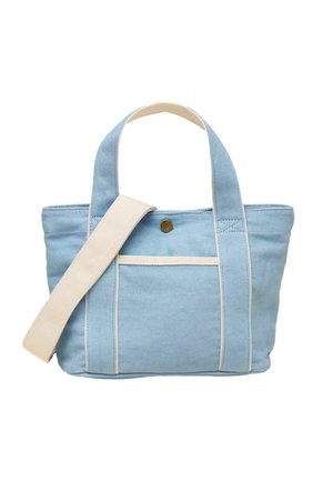 Light blue canvas tote bag with cream handles and removable shoulder strap, front pocket, and a single button closure.