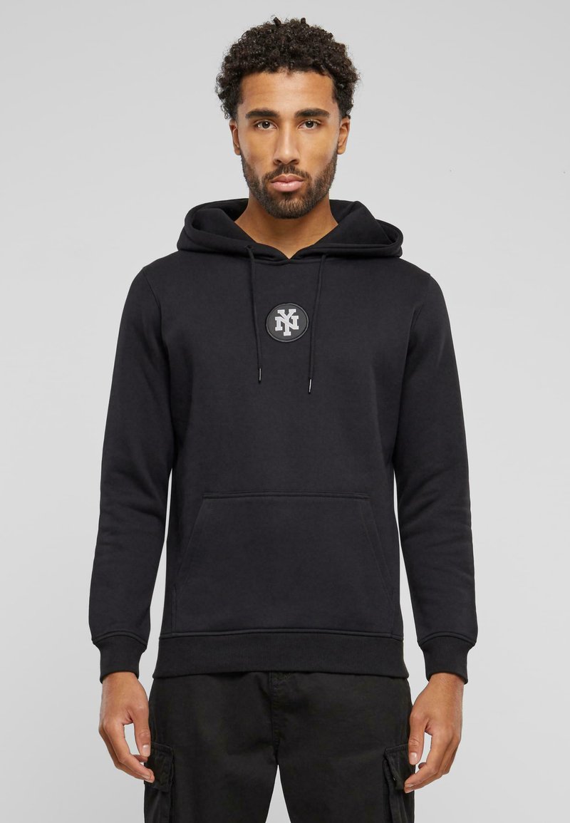 Zwarte hoodie van een katoenmix met een buidelzak, een capuchon met trekkoord en een ronde logo op de borst. Heeft ribgebreide manchetten en zoom.