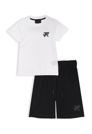 T-shirt bianca in cotone con logo nero sul petto, abbinata a pantaloni corti neri con vita elastica e accento logo sulla gamba sinistra.