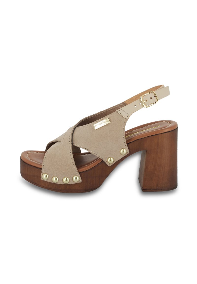 Sandal in suede beige con tacco a blocco in legno, design con cinturini incrociati e dettagli in oro. Cinturino alla caviglia regolabile con chiusura a fibbia.