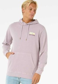 Lyse lilla hættetrøje lavet af blødt stof, med en kænguru-lomme, justerbare snore og et lille Rip Curl-logo på brystet.