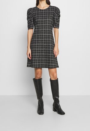 Vestido a cuadros negro con mangas cortas abullonadas, corsé ajustado, falda acampanada y botas de cuero negro hasta la rodilla. Textura de tela suave.