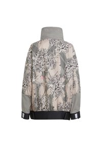 Giacca con motivo floreale su sfondo beige, bordi neri, maniche grigie e colletto alto. Presenta polsini elastici e una cintura nera.