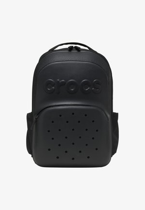 Sac à dos de marque Crocs noir avec un dessus texturé, poche avant zippée avec des trous de ventilation, et une poignée supérieure.