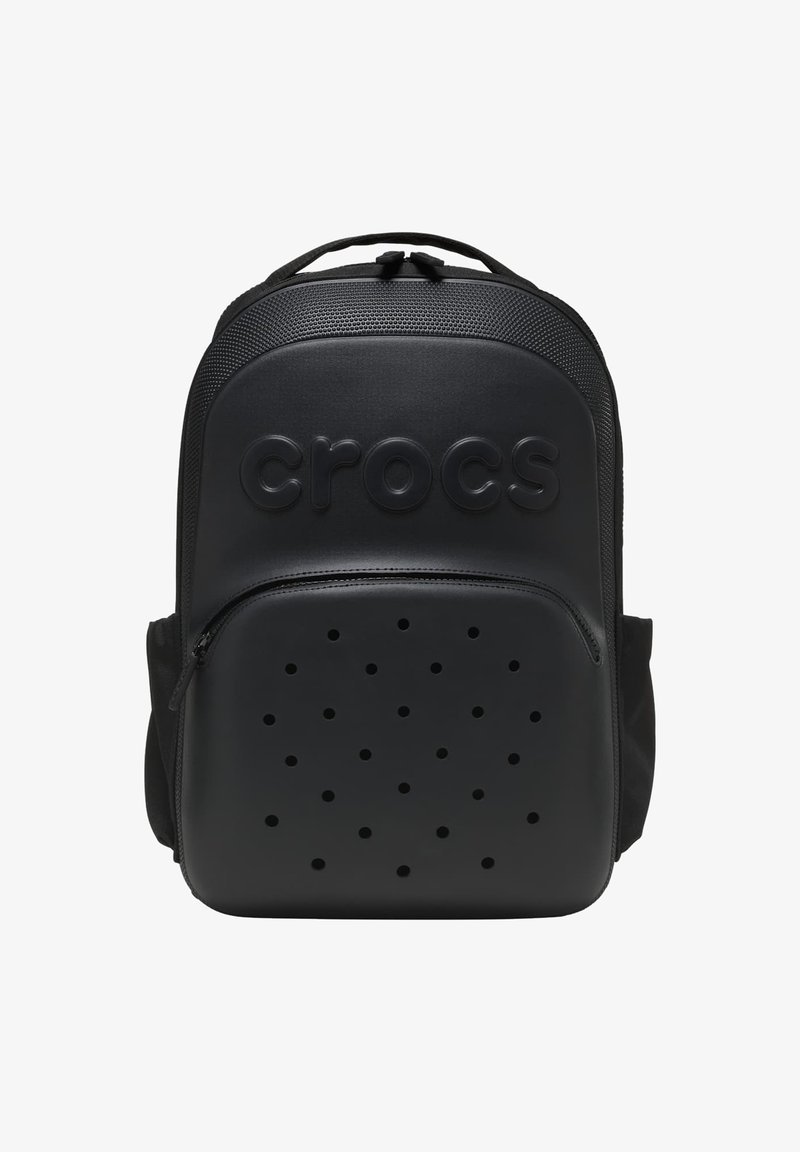 Sac à dos de marque Crocs noir avec un dessus texturé, poche avant zippée avec des trous de ventilation, et une poignée supérieure.