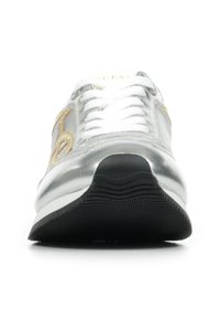 Zapatilla metálica plateada con cordones blancos, un acento dorado estampado en el lateral y una textura de suela de goma negra.