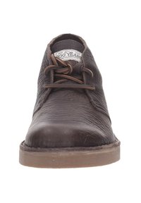 Donkerbruine leren veterschoen met een gestructureerde afwerking, ronde neus en een zachte zool. Bevat donkerbruine veters en een label dat zichtbaar is aan de binnenkant van de schoen.