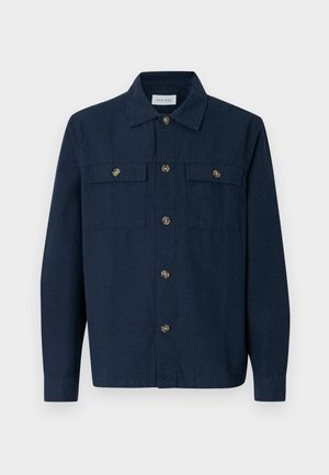 Marineblaue Hemdjacke aus Stoff mit glatter Textur, ausgestattet mit zwei Vordertaschen und goldfarbenen Knöpfen.