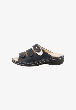 Sandale noire à bout ouvert avec trois lanières réglables, coutures blanches, semelle intérieure rembourrée et talon légèrement surélevé pour le confort.