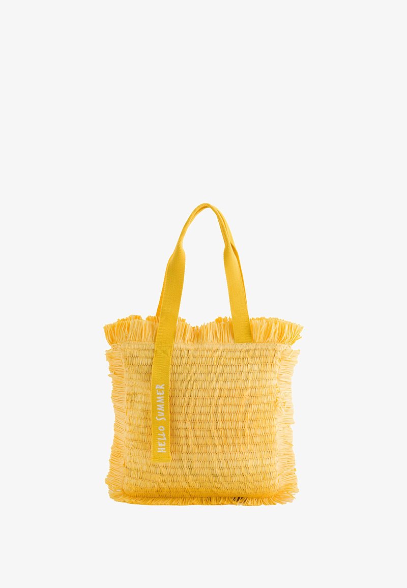 Sac de transport en paille jaune avec des bords frangés, équipé de deux poignées en tissu résistantes et portant l'inscription "BONJOUR ÉTÉ" sur une sangle. Léger et texturé.