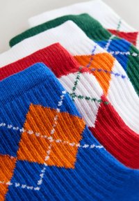Bunt gemusterte Socken mit einem Design aus orange und blauen Rauten und gerippter Textur; die Farben umfassen Blau, Rot, Grün, Weiß und Orange.