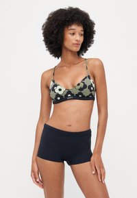 Svart og oliven grønn bikini-overdel med blomster- og geometriske mønstre, kombinert med marineblå boyshorts. Justerbare stropper, elastisk stoff.